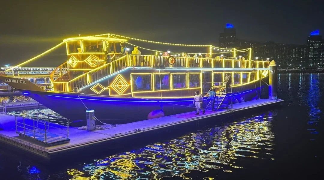 Traditional wooden dhow sailing through Dubai Canal at night – Dubai Canal Dhow Cruise