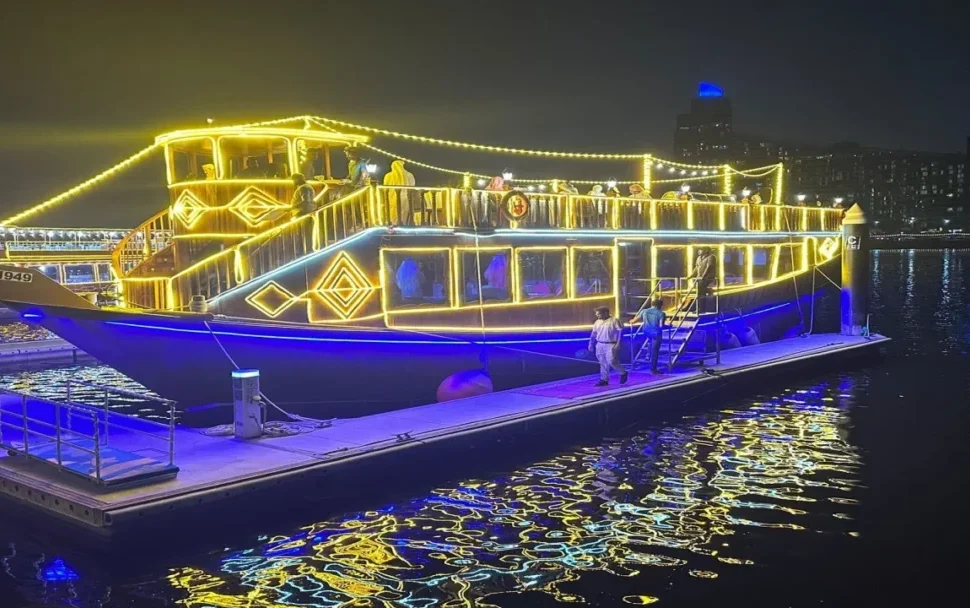 Traditional wooden dhow sailing through Dubai Canal at night – Dubai Canal Dhow Cruise