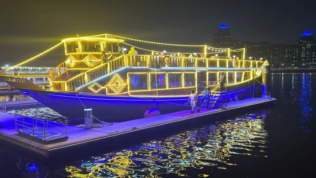 Traditional wooden dhow sailing through Dubai Canal at night – Dubai Canal Dhow Cruise