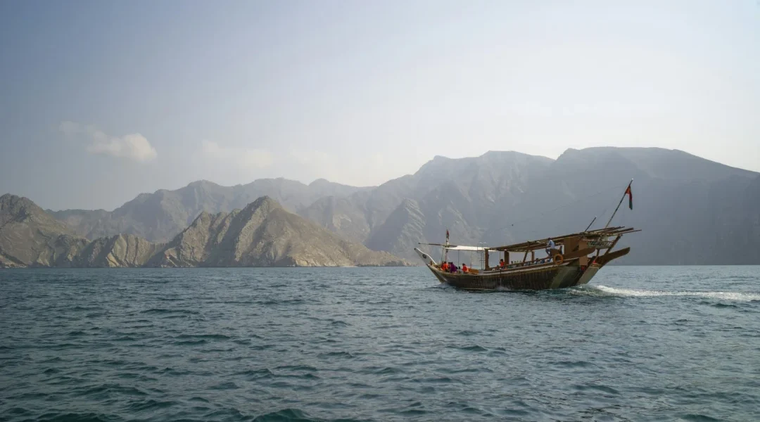 Traditional wooden dhow sailing through Musandam Dibba fjords on a Dhow Cruise Dibba Musandam