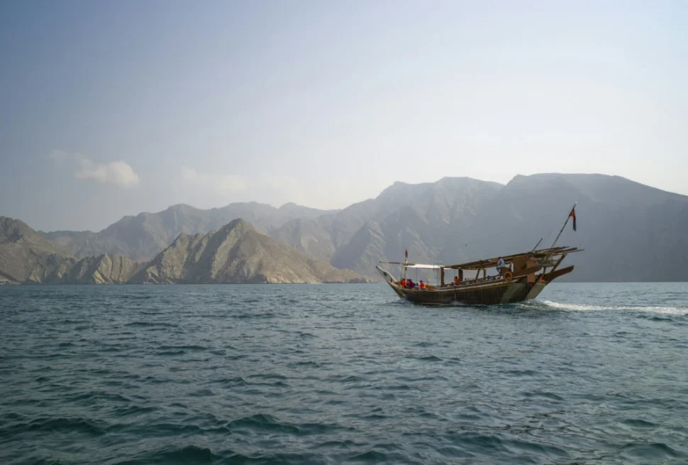 Traditional wooden dhow sailing through Musandam Dibba fjords on a Dhow Cruise Dibba Musandam
