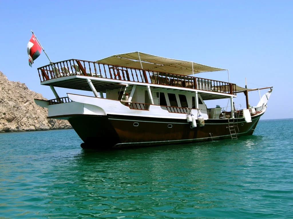 Traditional dhow sailing on crystal waters during a Musandam Dibba trip