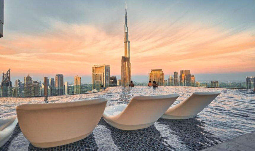 8 Lavish Dubai Pool Days Worth Spending Money On › Forever Tourism LLC Dubai Pool Days: Luxurious poolside view at a premium Dubai resort with cabanas and skyline in the background.