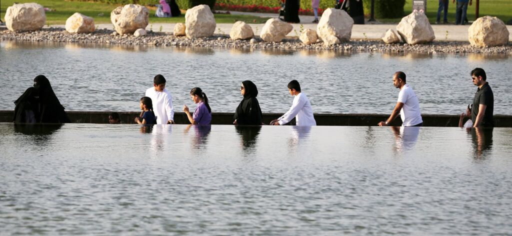 › Forever Tourism LLC Children and families enjoying Gardens and Playgrounds Near Dubai on a sunny day with greenery and Dubai skyline in the background.