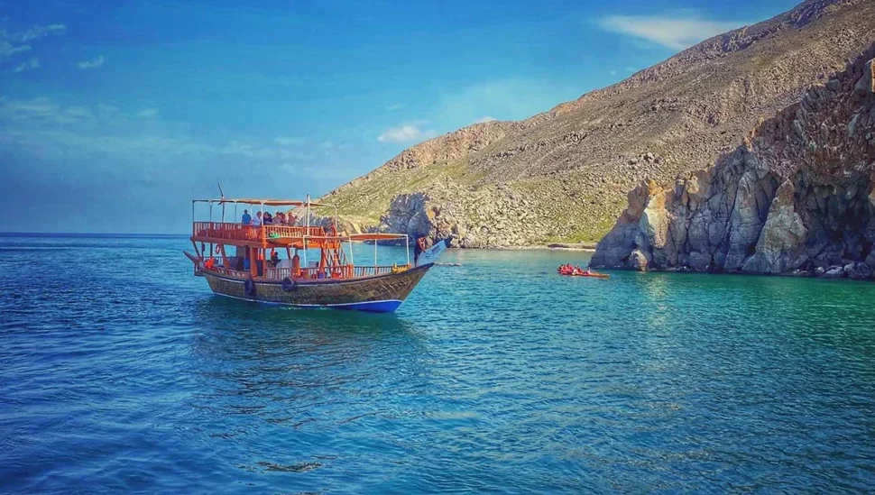 Traditional dhow sailing on crystal waters during a Musandam Dibba trip