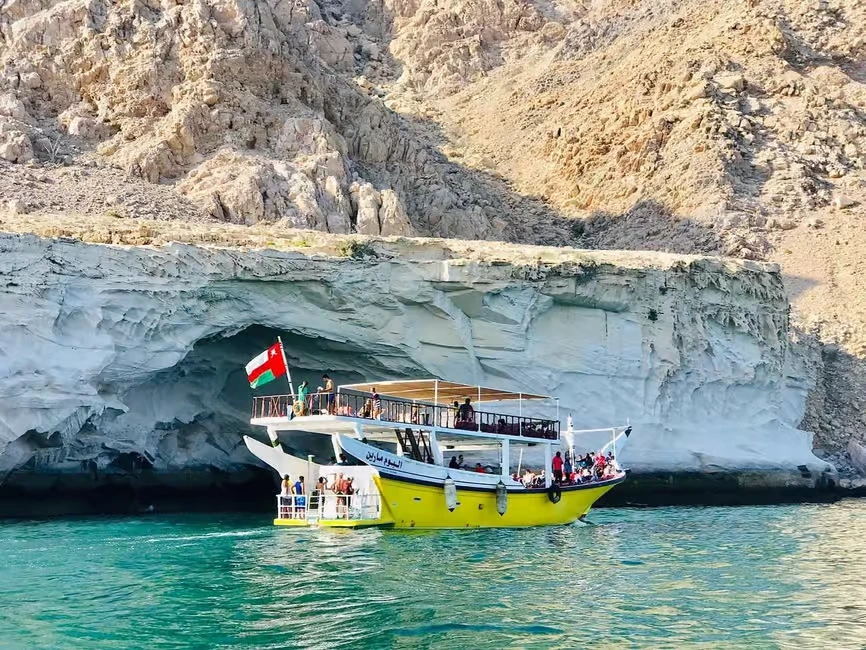 Traditional wooden dhow sailing through Musandam Dibba fjords on a Dhow Cruise Dibba Musandam