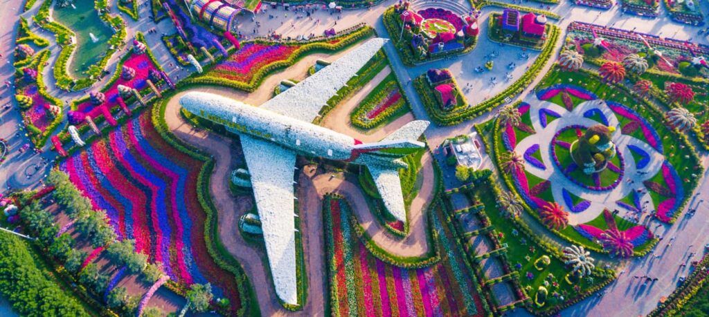 › Forever Tourism LLC Children and families enjoying Gardens and Playgrounds Near Dubai on a sunny day with greenery and Dubai skyline in the background.