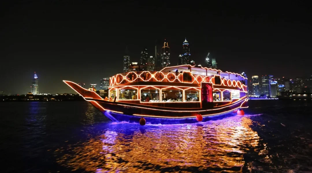 Couple enjoying a creek cruise dinner aboard a traditional dhow under Dubai’s night skyline