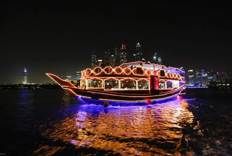 Couple enjoying a creek cruise dinner aboard a traditional dhow under Dubai’s night skyline