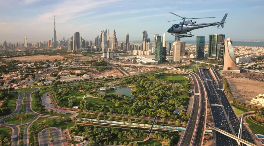 A breathtaking aerial view of Dubai’s skyline with a helicopter in Dubai flying over iconic landmarks