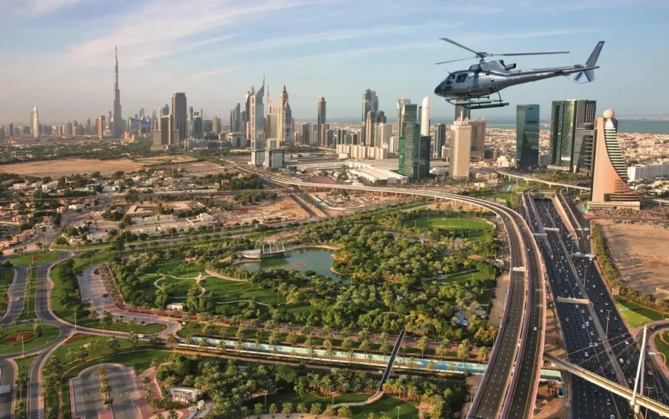 A breathtaking aerial view of Dubai’s skyline with a helicopter in Dubai flying over iconic landmarks