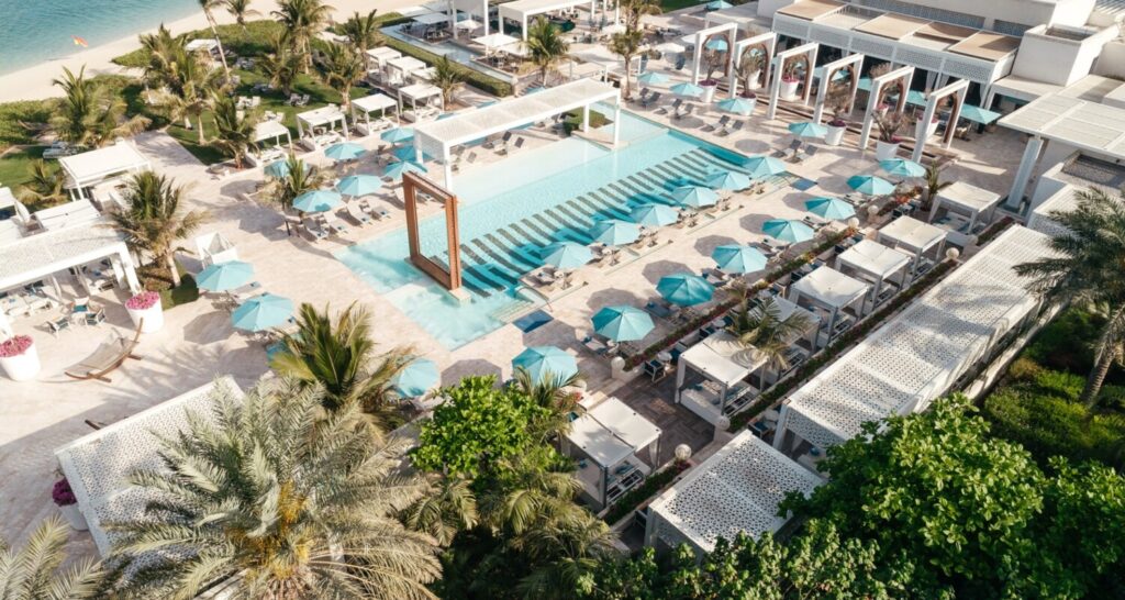 Dubai Pool Days: Luxurious poolside view at a premium Dubai resort with cabanas and skyline in the background.