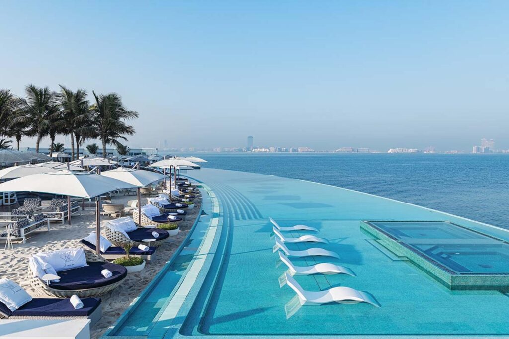 Luxurious poolside view at a premium Dubai resort with cabanas and skyline in the background