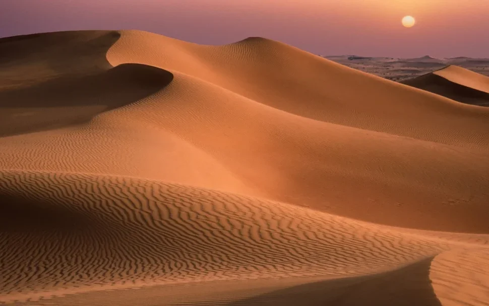 4×4 cresting red dunes at sunset during a desert trip Dubai