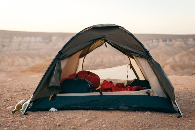 Al-Qudra-Desert › Forever Tourism LLC Al Qudra desert camping at sunset with tents, lanterns, and dunes