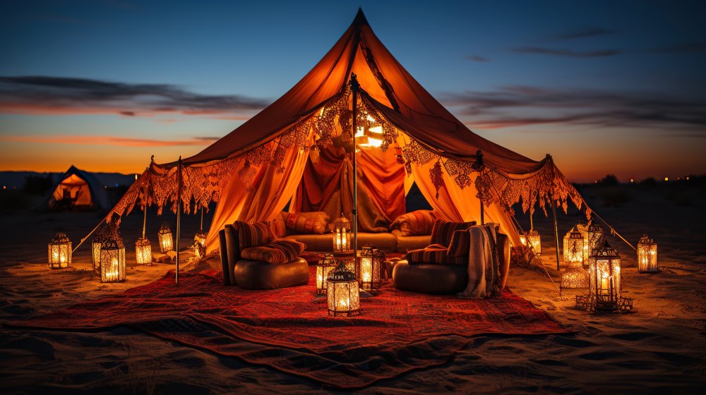 Luxury desert tent setup during deluxe overnight safari with lanterns, cushions, and sunset sky