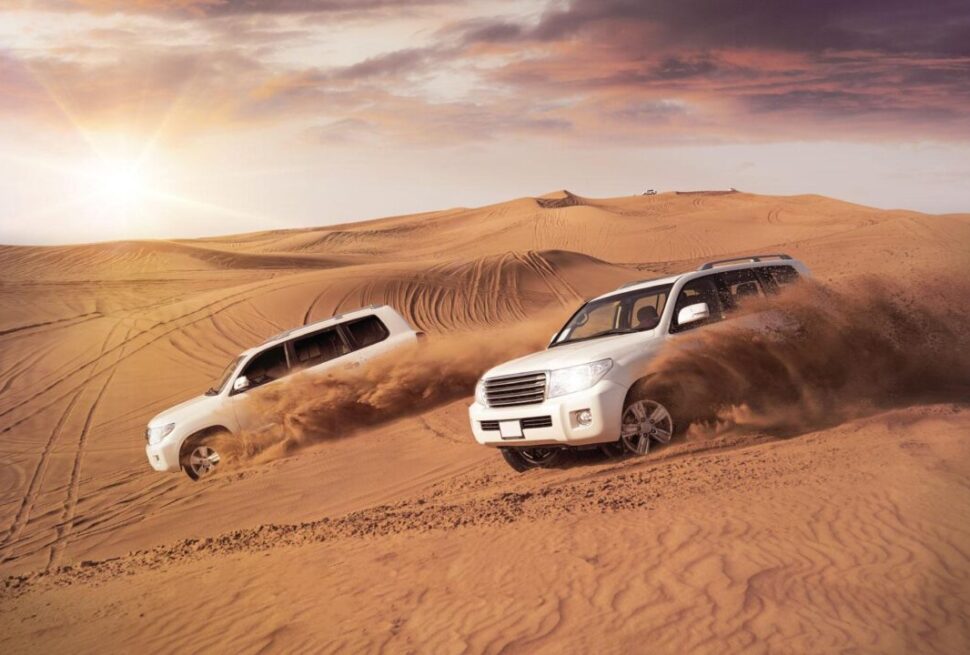 Tourists enjoying desert experience Dubai with camel ride at sunset