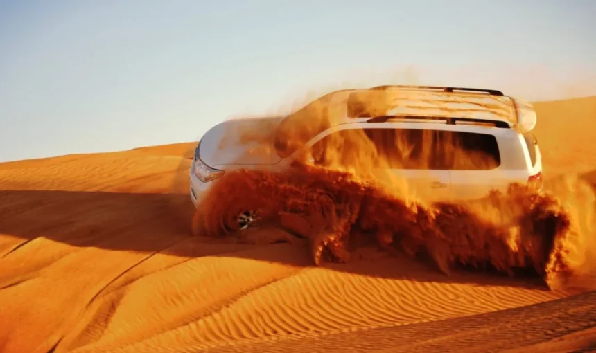 Thrilling Desert Safari Drive Across Golden Dunes › Forever Tourism LLC A white 4x4 SUV powers through golden sand dunes during a thrilling Desert Safari Drive, with sand spraying dramatically into the air.