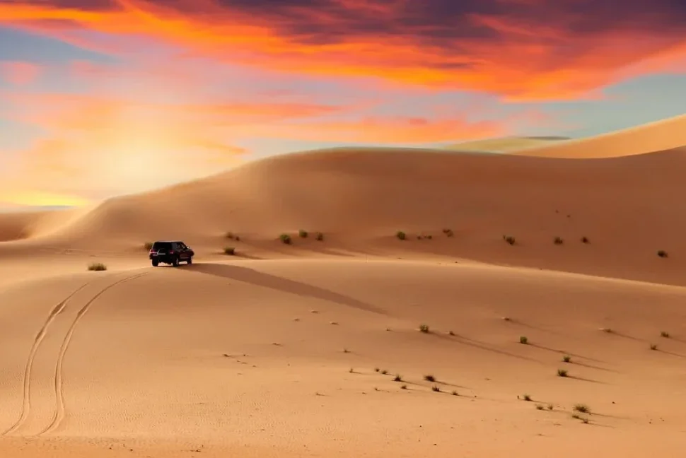 4×4 cresting red dunes at golden hour during a desert safari tour in Dubai