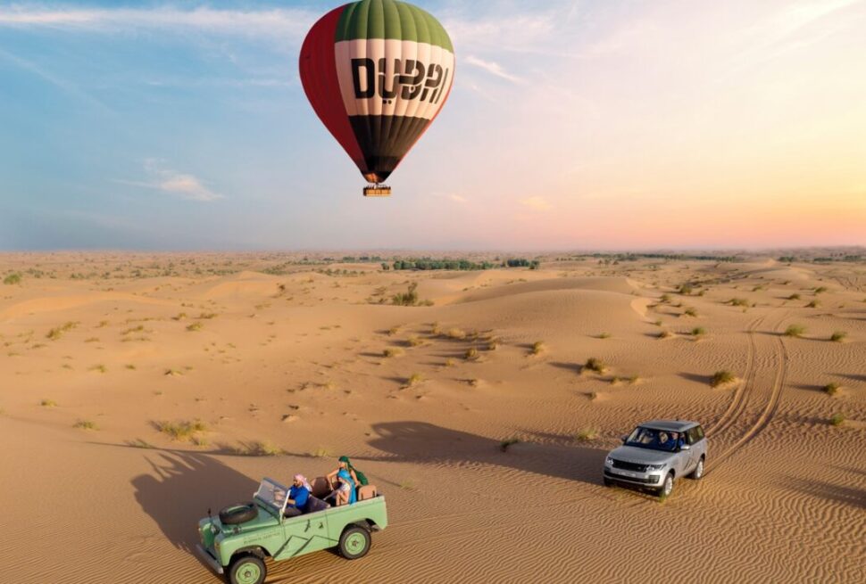 Dubai Desert Safari package with 4×4 on red dunes, camel ride, and camp lights