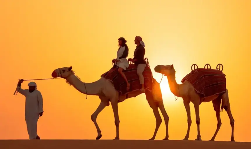 › Forever Tourism LLC Arabian Safari on red dunes at sunset with 4×4, camel ride, and lantern-lit camp