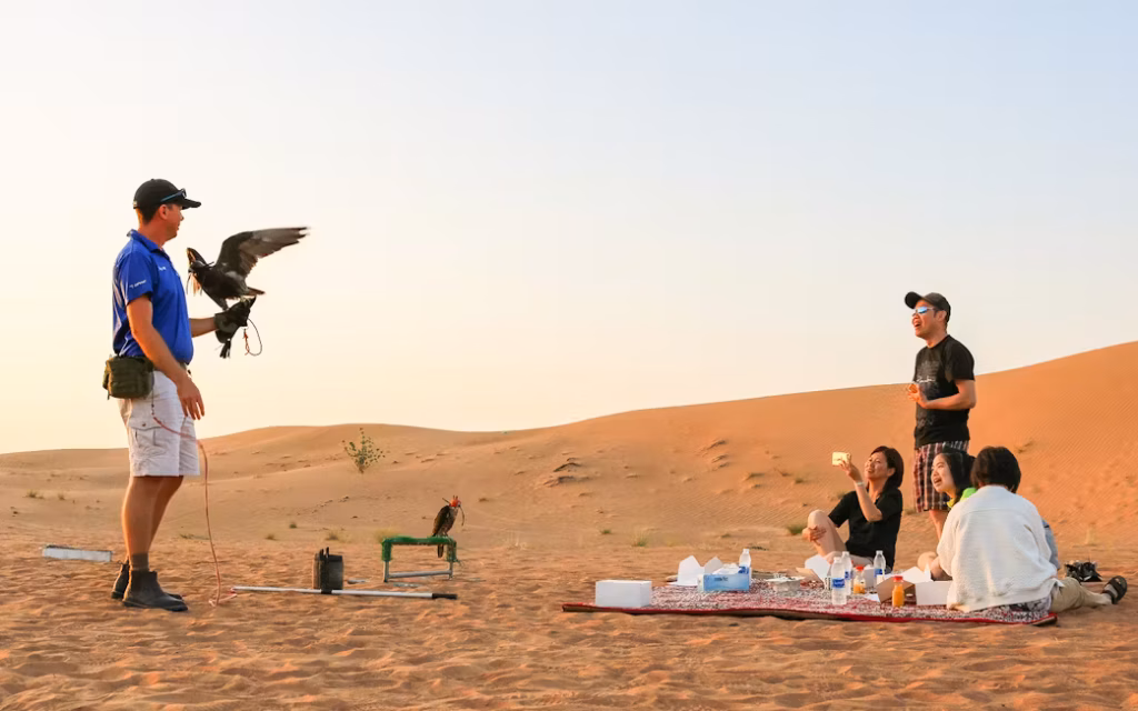 Dubai Desert Safari 4×4 on red dunes at sunset with lantern-lit camp