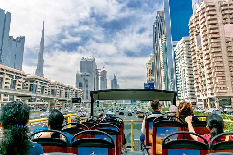 › Forever Tourism LLC Big Bus Tours Dubai hop-on hop-off bus passing Burj Khalifa and Dubai skyline