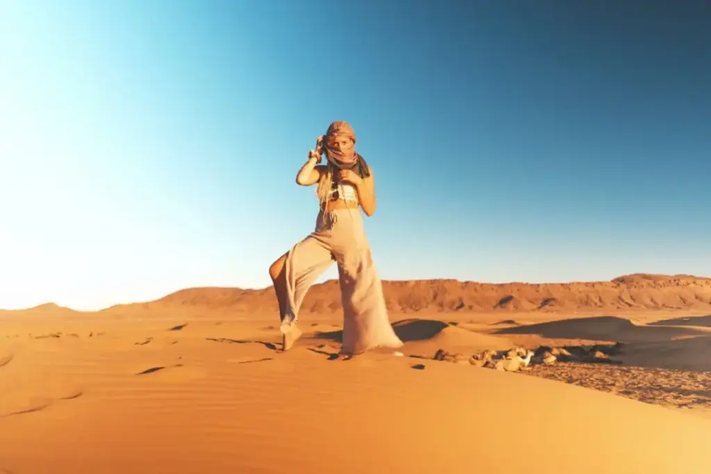 desert safari outfit ideas with breathable layers, hat, scarf, and closed shoes on Dubai dunes