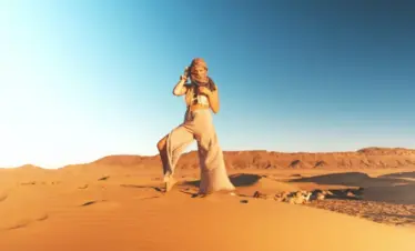 desert safari outfit ideas with breathable layers, hat, scarf, and closed shoes on Dubai dunes