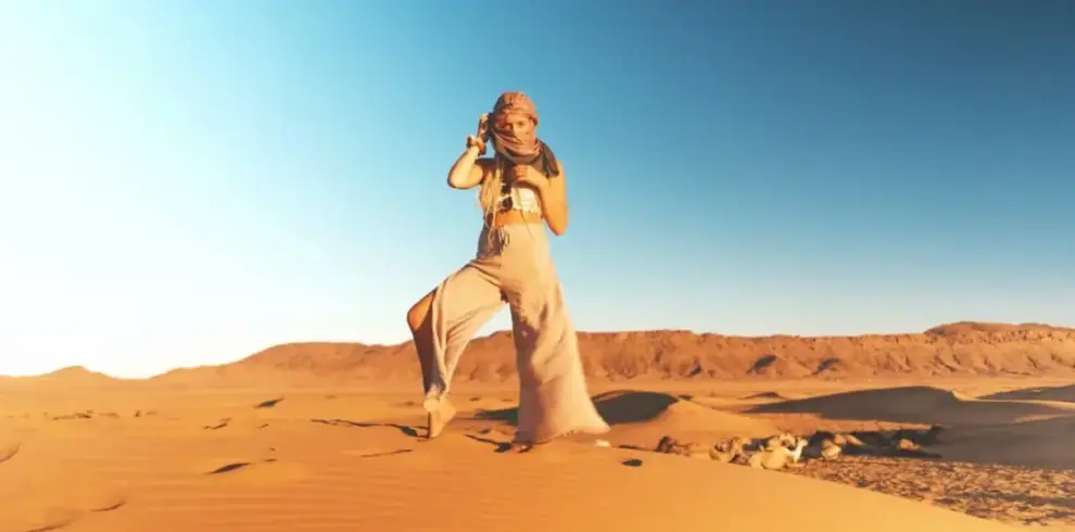 desert safari outfit ideas with breathable layers, hat, scarf, and closed shoes on Dubai dunes