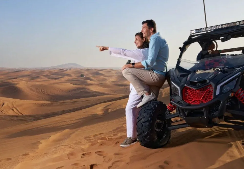 Dubai Desert Safari package with 4×4 on red dunes, camel ride, and camp lights