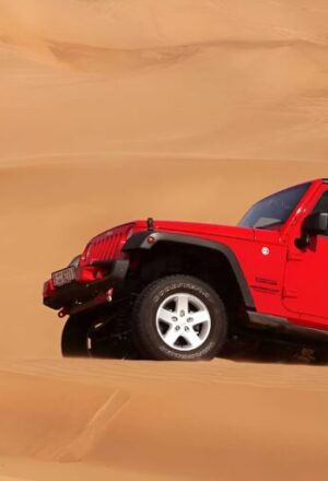 jeep safari Dubai 4x4 on red dunes at sunset with riders