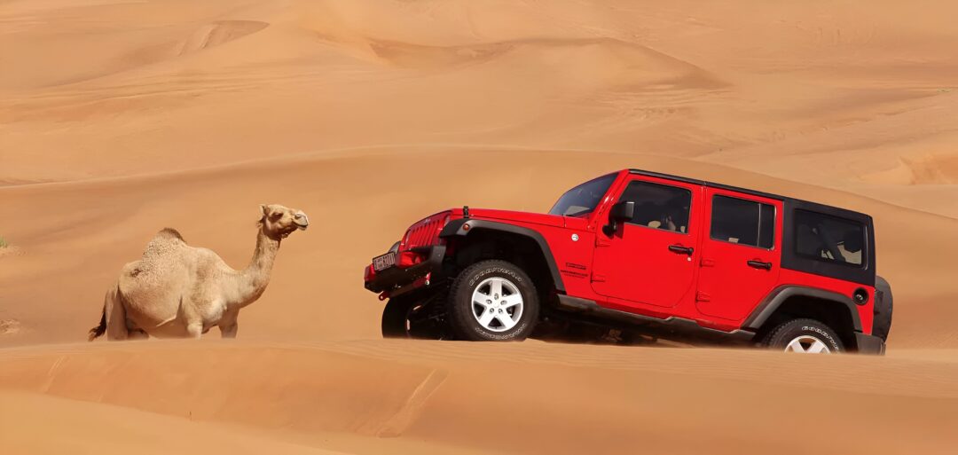 jeep safari Dubai 4x4 on red dunes at sunset with riders