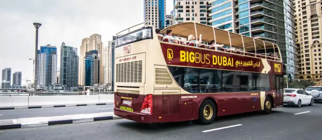 › Forever Tourism LLC Big Bus Tours Dubai hop-on hop-off bus passing Burj Khalifa and Dubai skyline