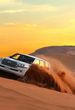 desert safari Dubai 4x4 on red dunes at sunset with camp lights