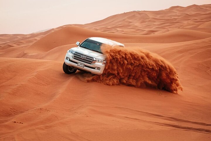family desert safari Dubai with parents and kids on red dunes at sunset