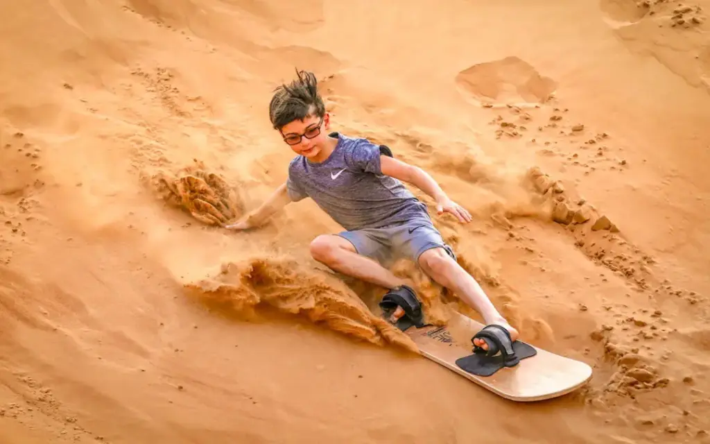 kid friendly › Forever Tourism LLC Red Dunes Desert Safari with 4×4 cresting red dunes at sunset and lantern-lit camp