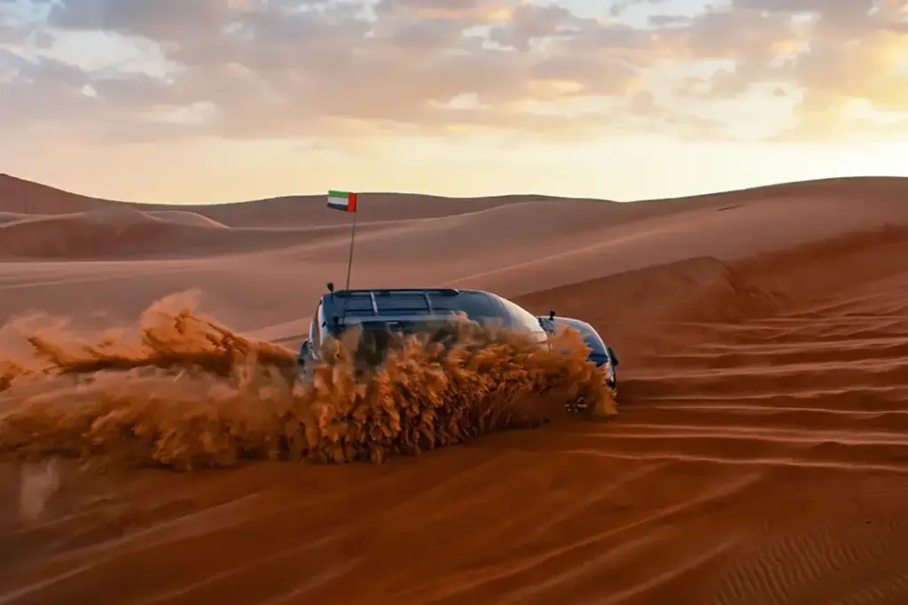red dunes Dubai at sunset with 4×4, camel ride, and camp lights