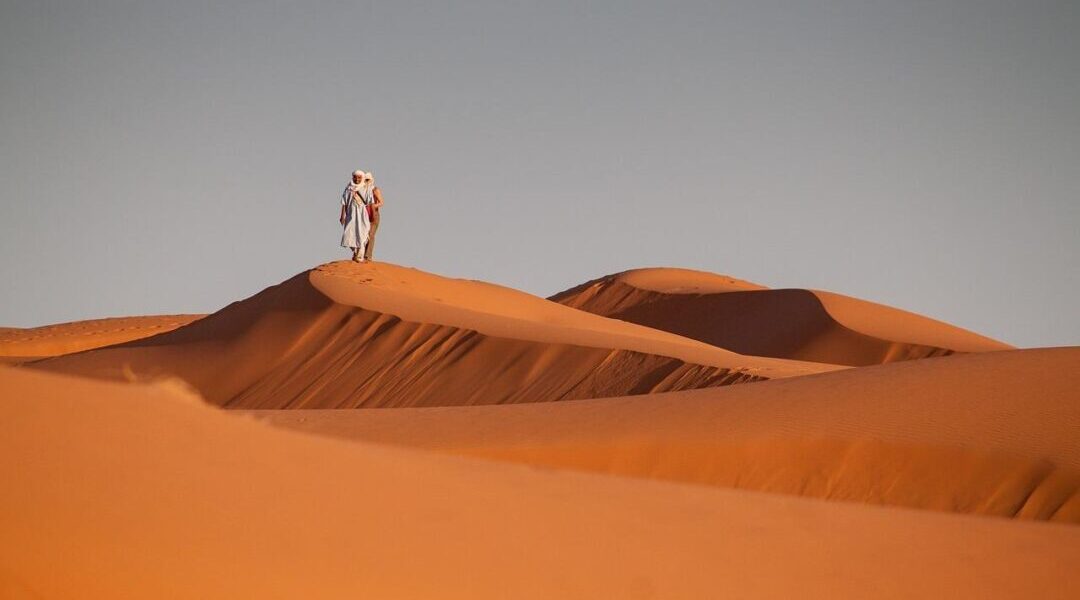 Red Dunes Desert Safari: Sunset Thrills & VIP Options › Forever Tourism LLC Red Dunes Desert Safari with 4×4 cresting red dunes at sunset and lantern-lit camp