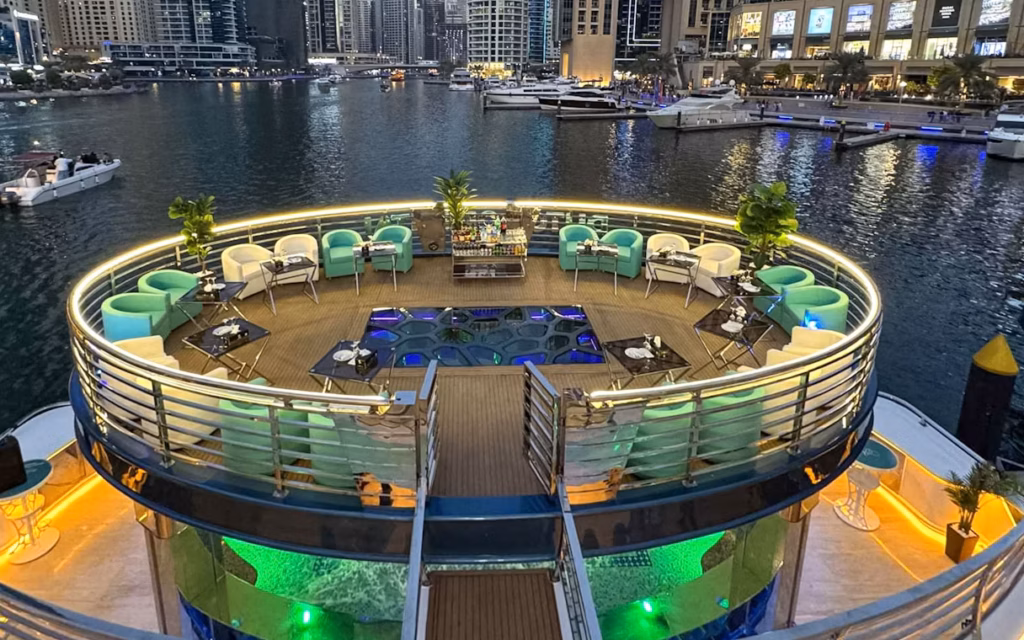 Lotus Cruise Dubai mega yacht dinner with city skyline and guests on deck