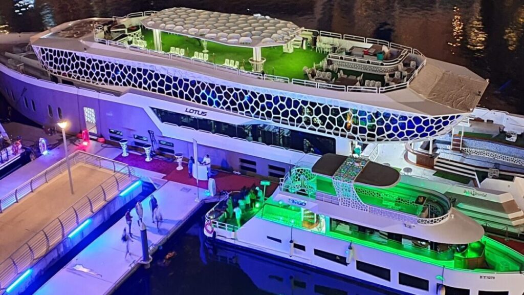 Lotus Cruise Dubai mega yacht dinner with city skyline and guests on deck
