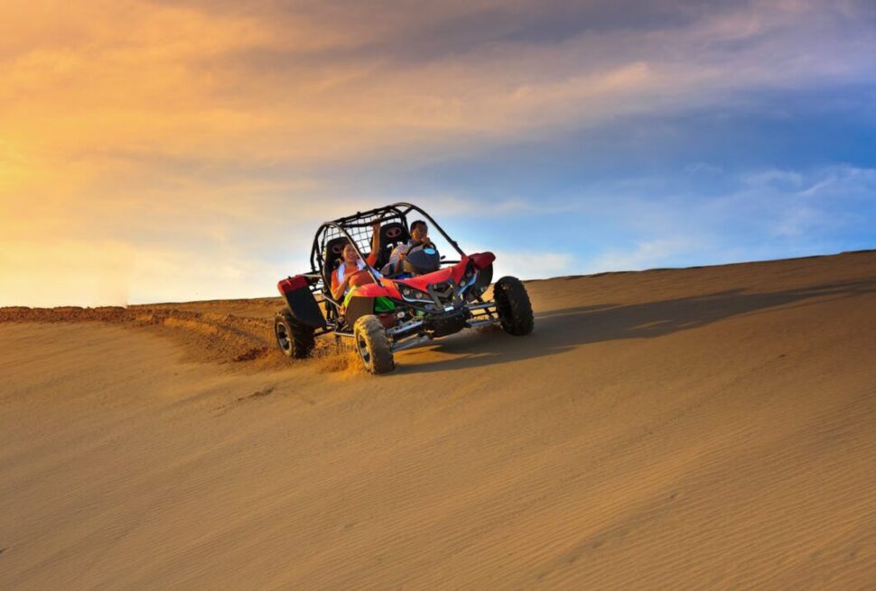 buggy desert safari Dubai with rider speeding across red dunes
