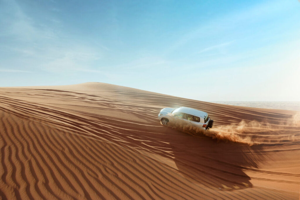4x4 vehicle dune bashing at the desert safari dubai offers location across golden sand dunes in the United Arab Emirates.