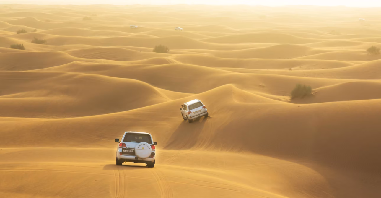4x4 vehicle driving over golden sand dunes during a desert Safari Dubai adventure.