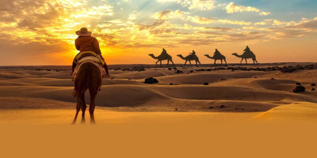 Camel riders enjoying a sunset desert trip Abu Dhabi across golden dunes and peaceful landscapes.