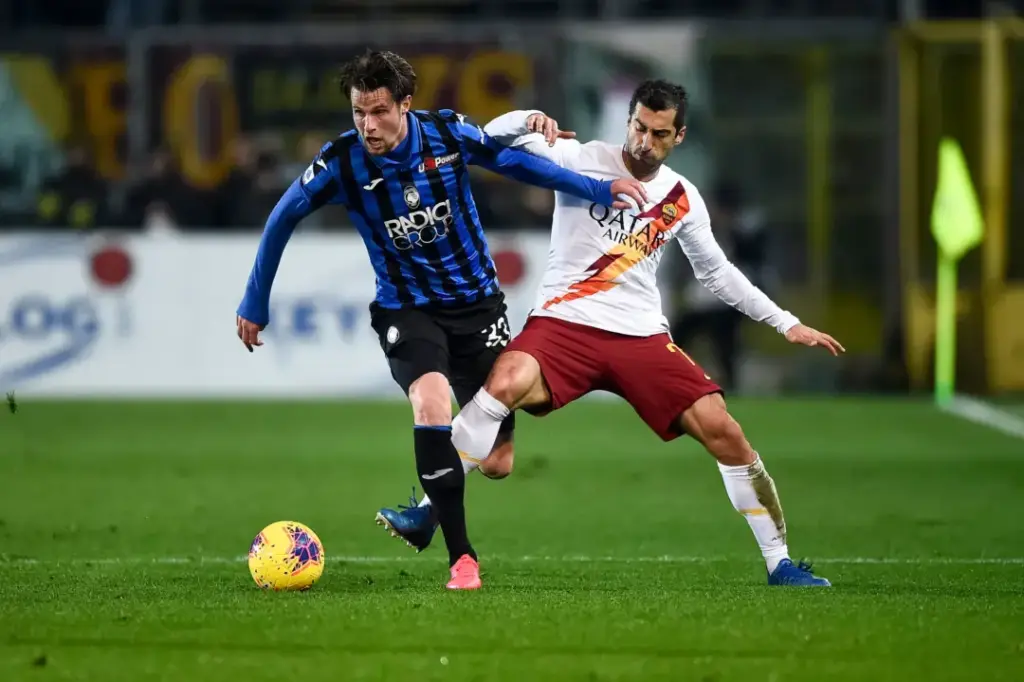Atalanta vs Roma Serie A showdown featuring an Atalanta player battling a Roma defender for possession in a high-intensity Italian football match.