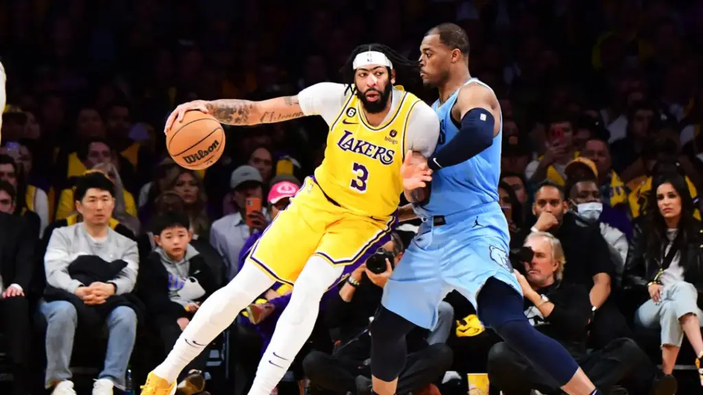 “Lakers vs Grizzlies NBA game showing Anthony Davis driving past a Grizzlies defender”