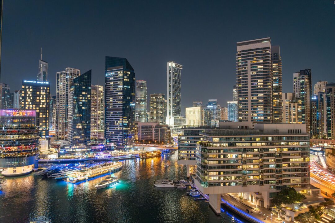 Nightlife in Dubai during Ramadan at Dubai Marina with illuminated skyscrapers and waterfront dining boats after sunset