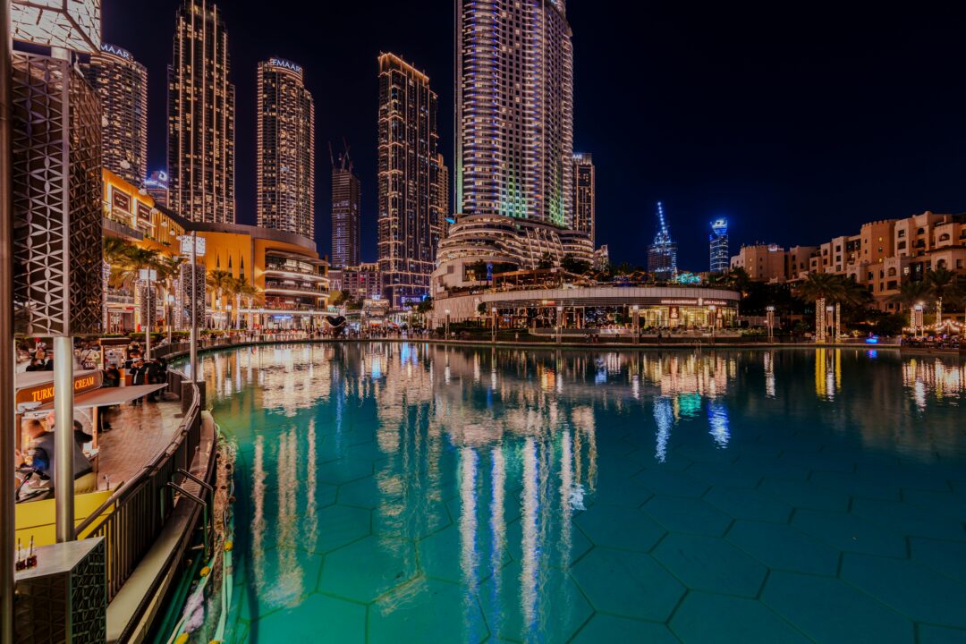 Downtown Dubai waterfront illuminated at night during Ramadan Dubai 2026 with city lights reflecting on the lake