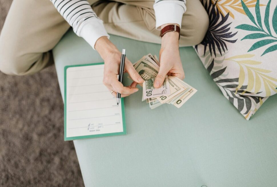 Person holding cash and reviewing documents, representing financial proof requirement under the 3000 Dirham rule UAE for travellers.